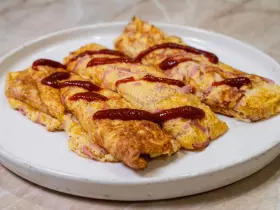 Яичные рулетики с сыром и колбасой на сковороде